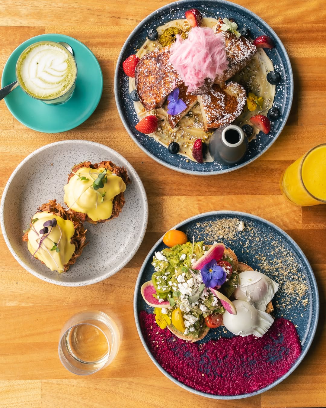 Vibrant overhead brunch spread with French toast, eggs Benedict, and avocado toast